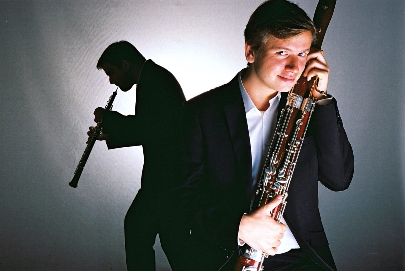 Portrait de Kimiko Imani avec son frères musicien en arrière plan en silhouette noire avec leurs instruments de musique