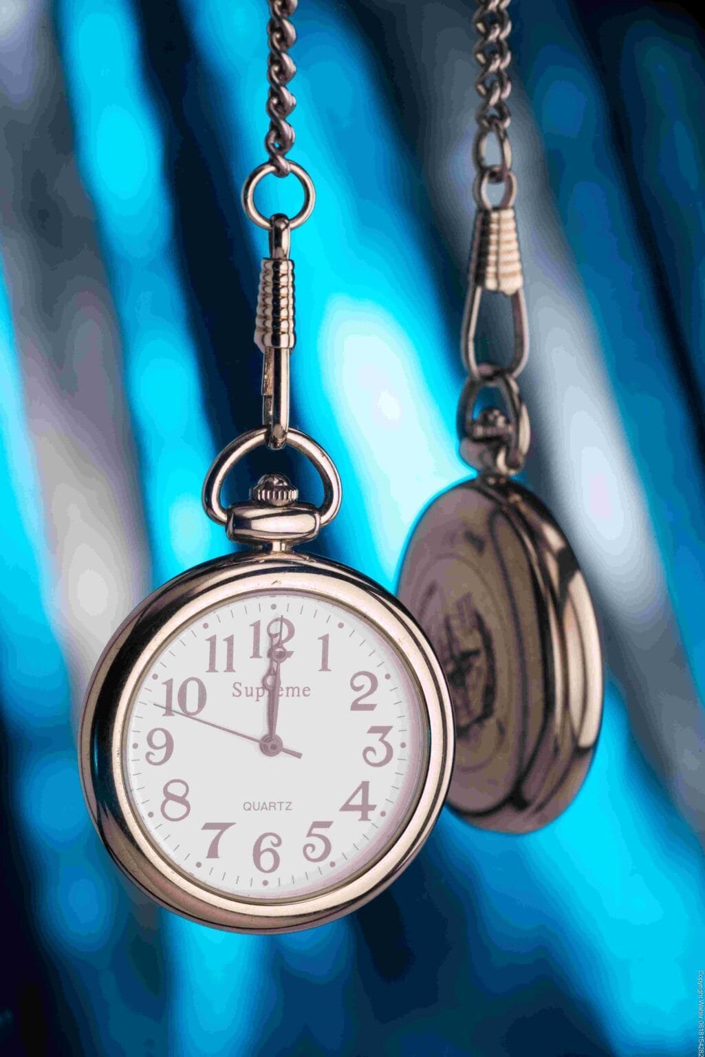 Montre suspendu devant un miroir avec un arrière plan bleu
