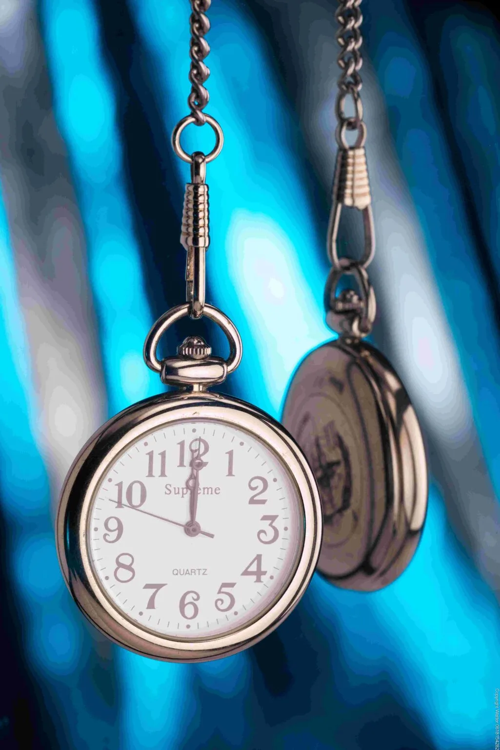Montre suspendu devant un miroir avec un arrière plan bleu