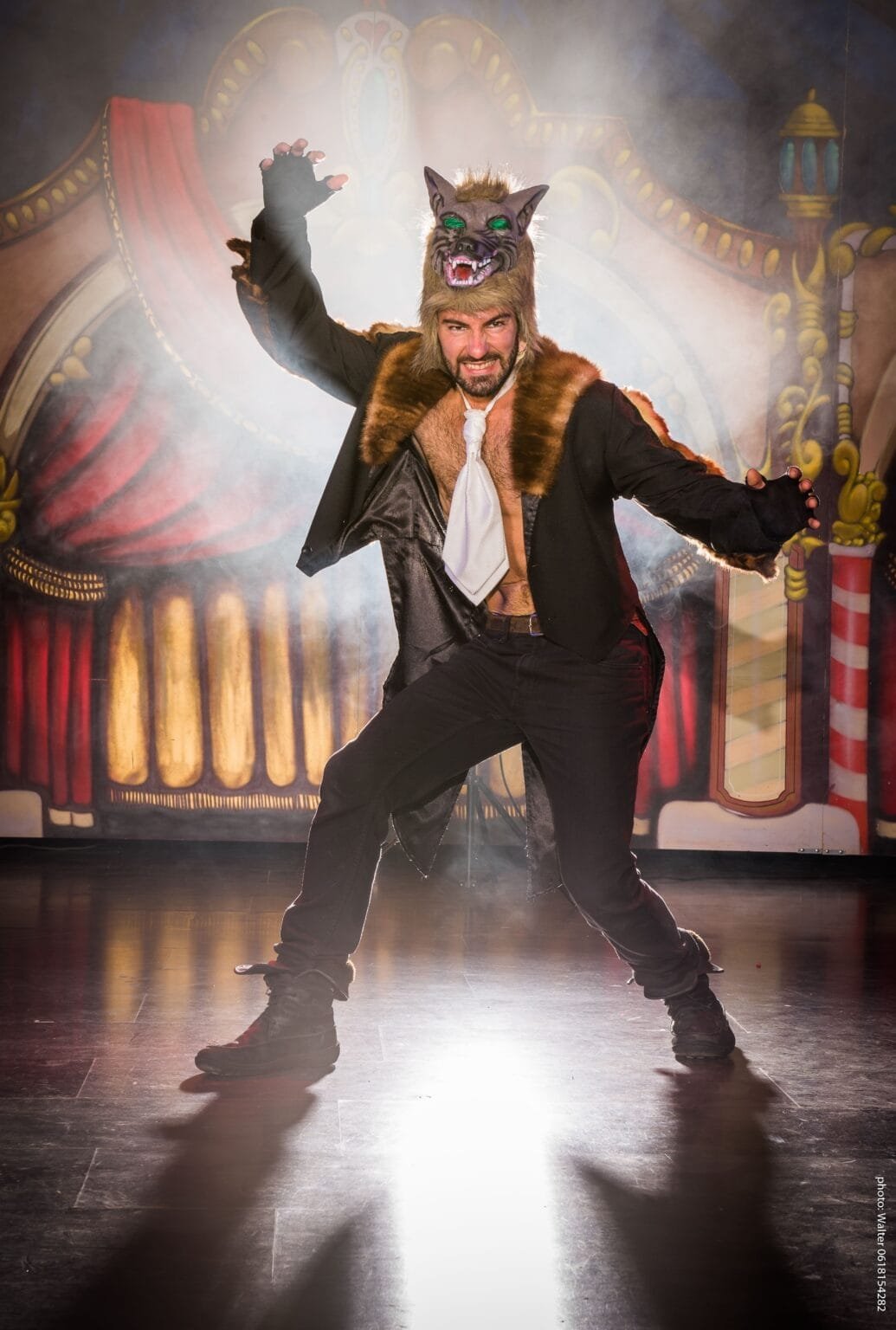 Danseur de music-hall déguisé en loup sur scene en contrejour